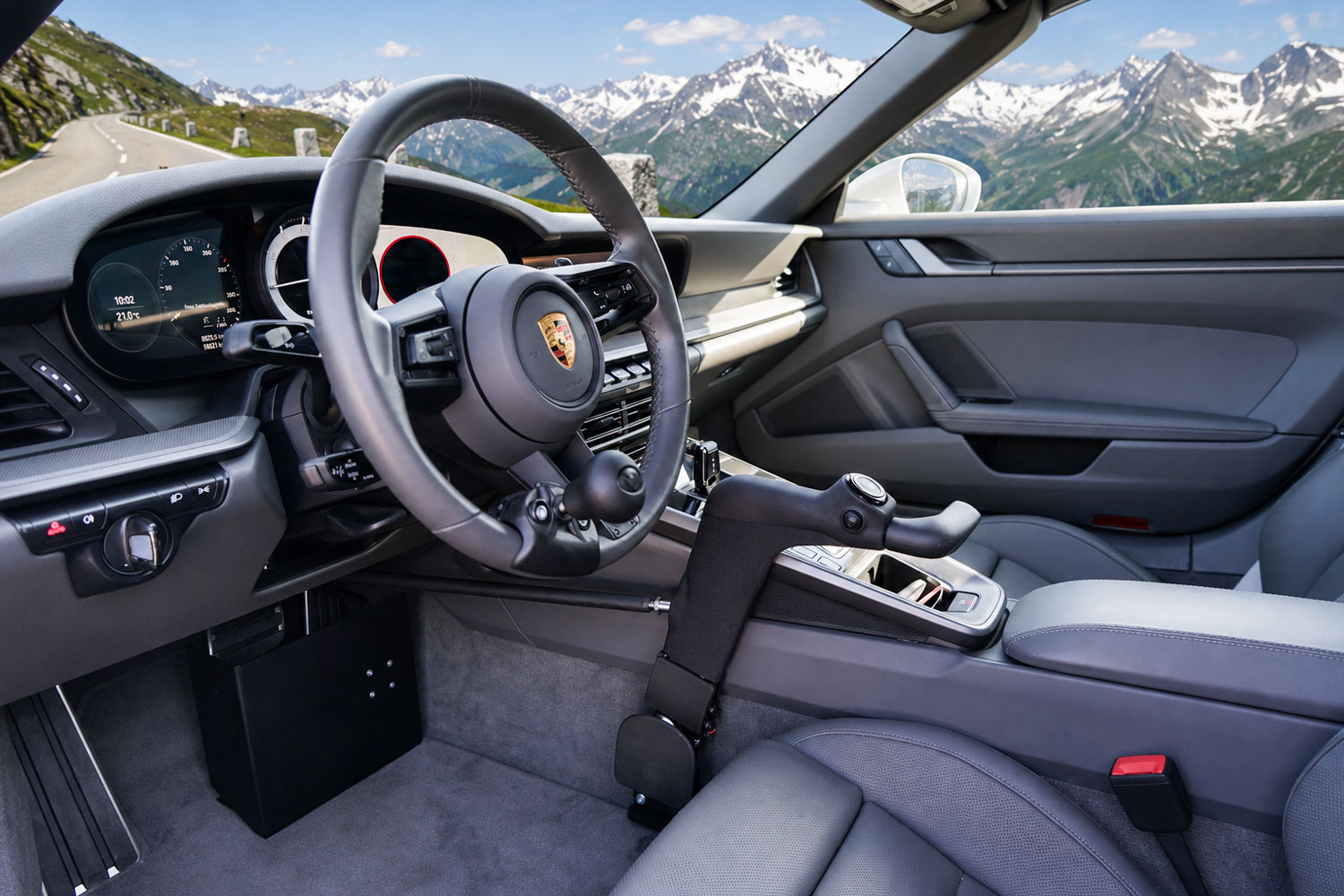 Innenraumansicht im behindertengerechten Porsche Targa 911 mit Handgerät für Gas und Bremse, Lenkradknauf und herausnehmbarer Pedalsperre