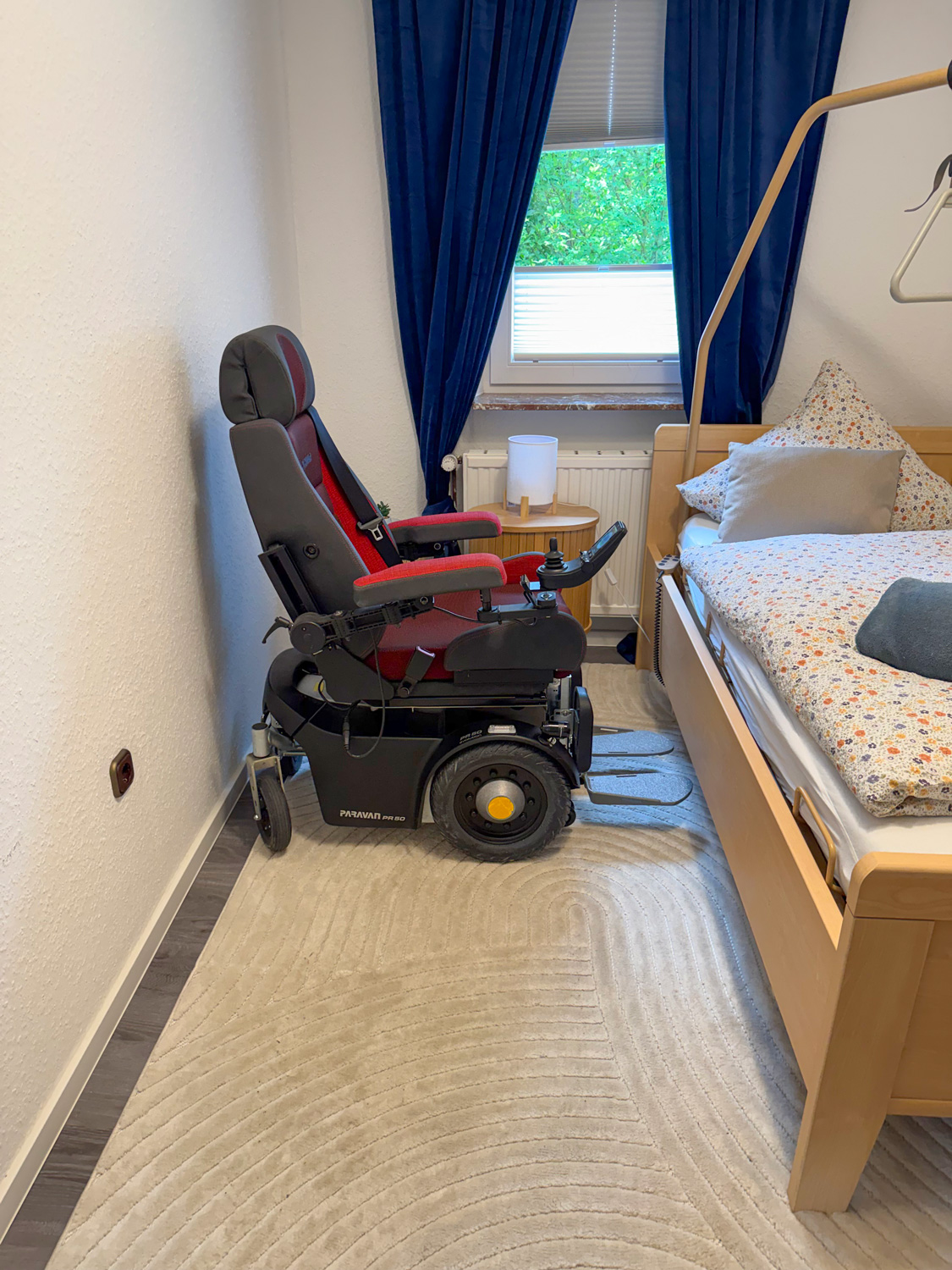 Schlafzimmer mit Pflegebett, genug Platz auch für breite Elektrorollstühle