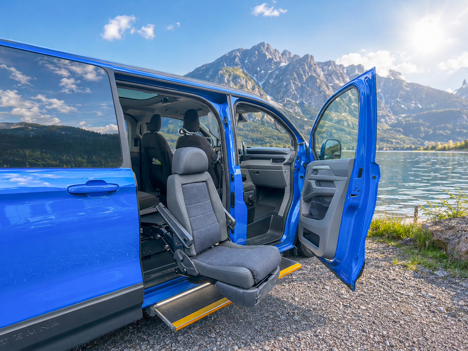 behindertengerechter Volkswagen Caravelle am See mit 2 elektrischen Trittstufen auf der Beifahrerseite, außerdem ein Hubschwenksitz