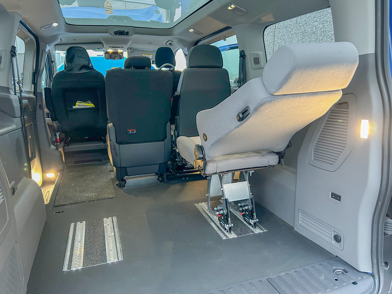 behindertengerechter Volkswagen Caravelle Innenraum mit zwei Alurasterschienen zum flexiblen Anpassen des verstellbaren Sitzes