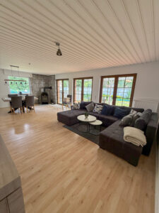 Barrierefreundliche Ferienwohnung Haus Sodermanns, geräumiges Wohnzimmer mit Sofa und Esstisch, Ausgang zur Terasse und Garten